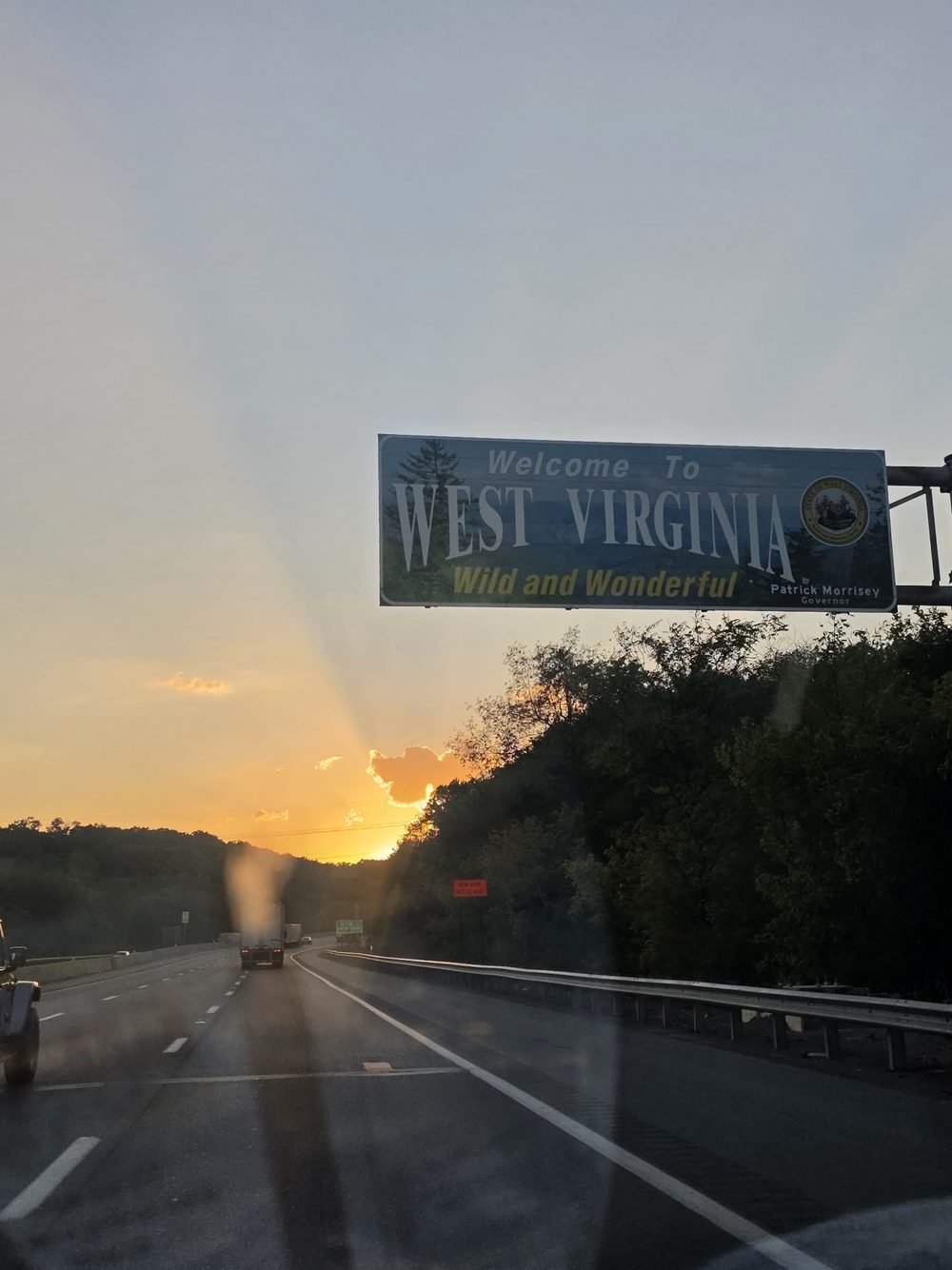 Welcome to West Virginia sign at sunset on the drive down